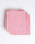 Folded pink towel on a white background